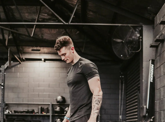 Fit young man with tattoo training in industrial gym environment for strength and metabolic health