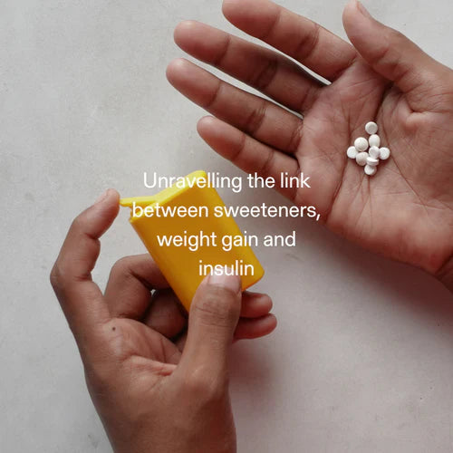 Hands holding artificial sweeteners and dispenser, exploring effects on insulin, weight gain, and hunger regulation