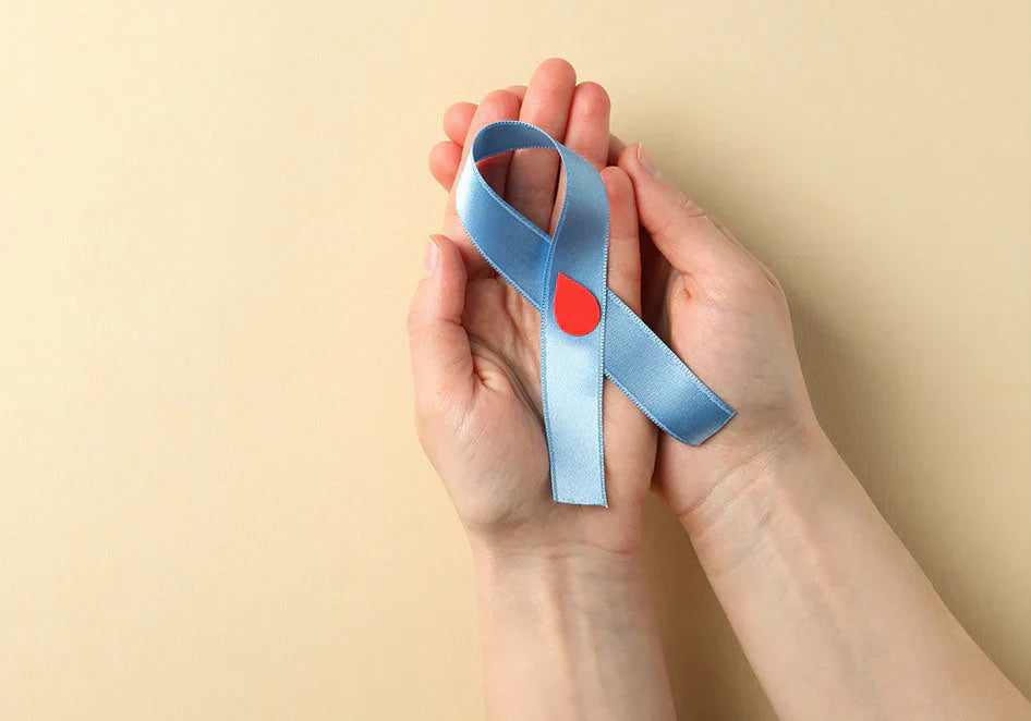 Hands holding diabetes awareness ribbon with red drop symbol on beige background