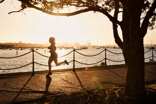 Woman jogging by the water at sunset with GLP-1 metabolism and appetite support