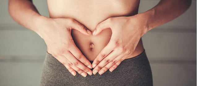 Hands forming a heart shape over a healthy gut, symbolizing digestive wellness