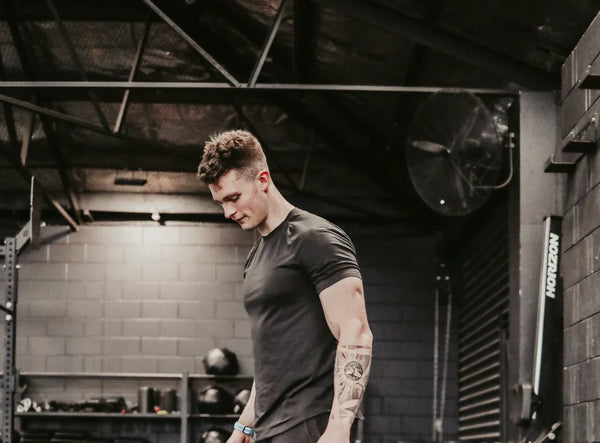 Fit young man with tattoo training in industrial gym environment for strength and metabolic health