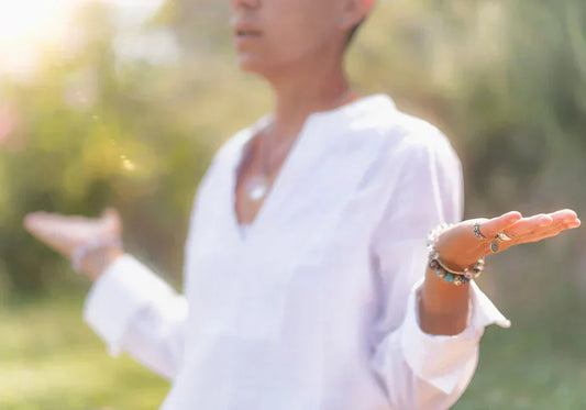 Woman practicing mindfulness and balance outdoors with open hands and peaceful expression