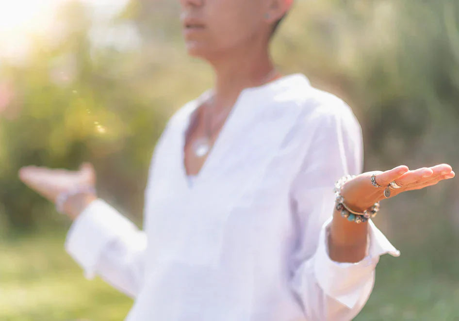 Woman practicing mindfulness and balance outdoors with open hands and peaceful expression