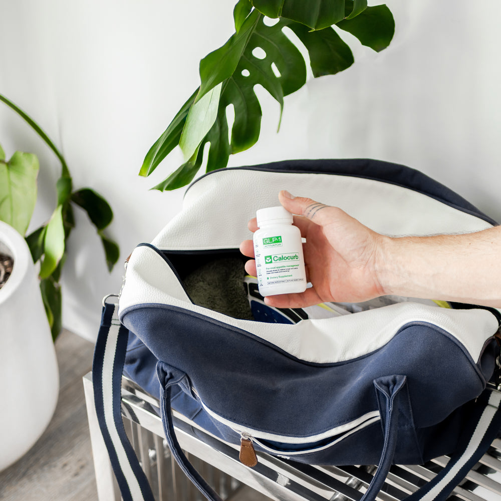 Hand placing Calocurb GLP-1 supplement bottle into gym bag – natural plant-based appetite control support on the go