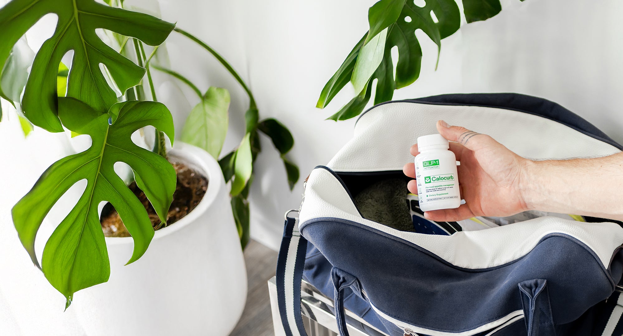 Person holding a bottle of Calocurb next to a bag with plants in the background